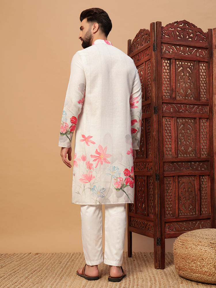 Man wearing a floral kurta with white pants in front of a wooden carved screen.