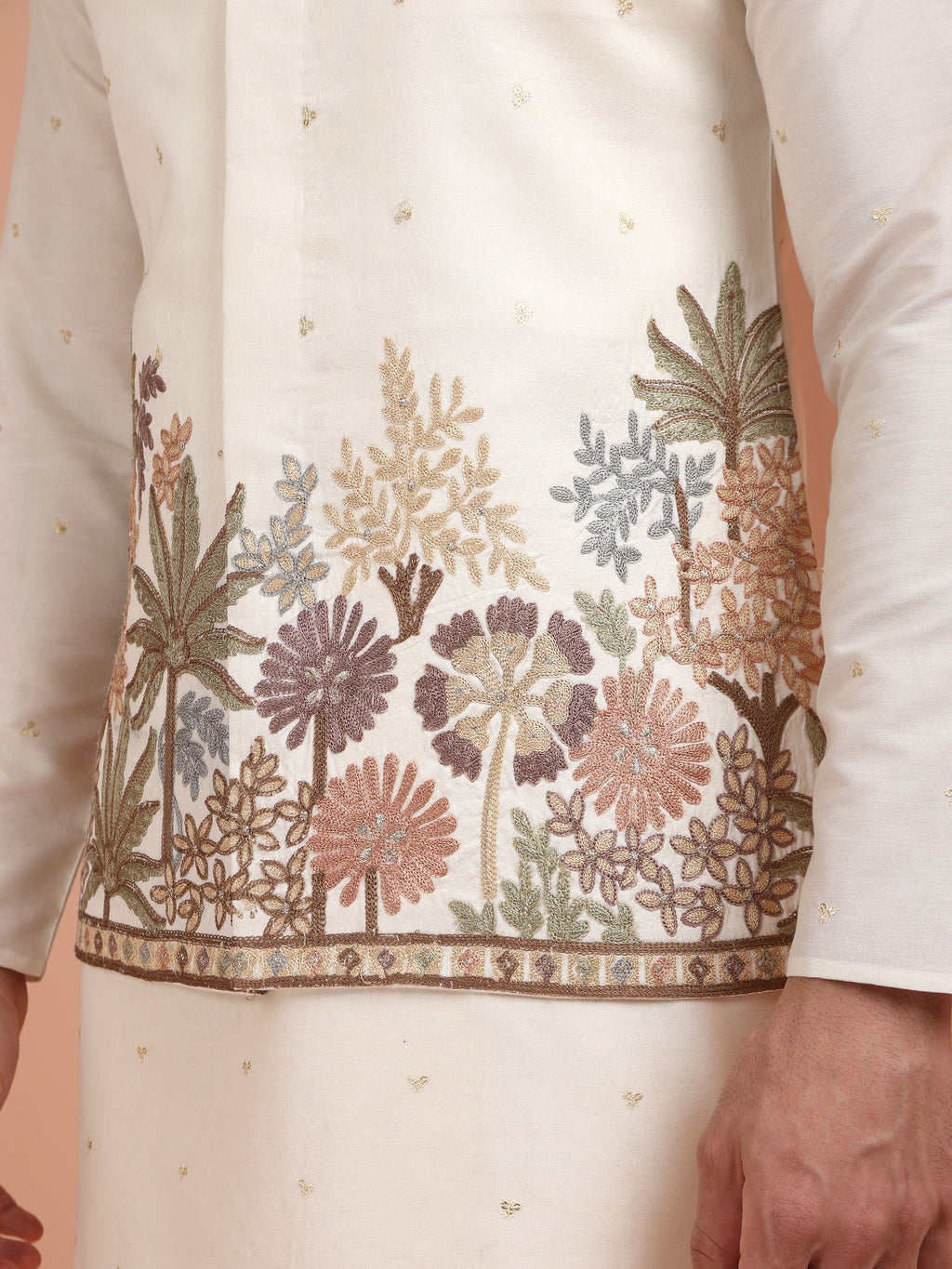 Close-up of a white outfit with floral embroidery on a plain background
