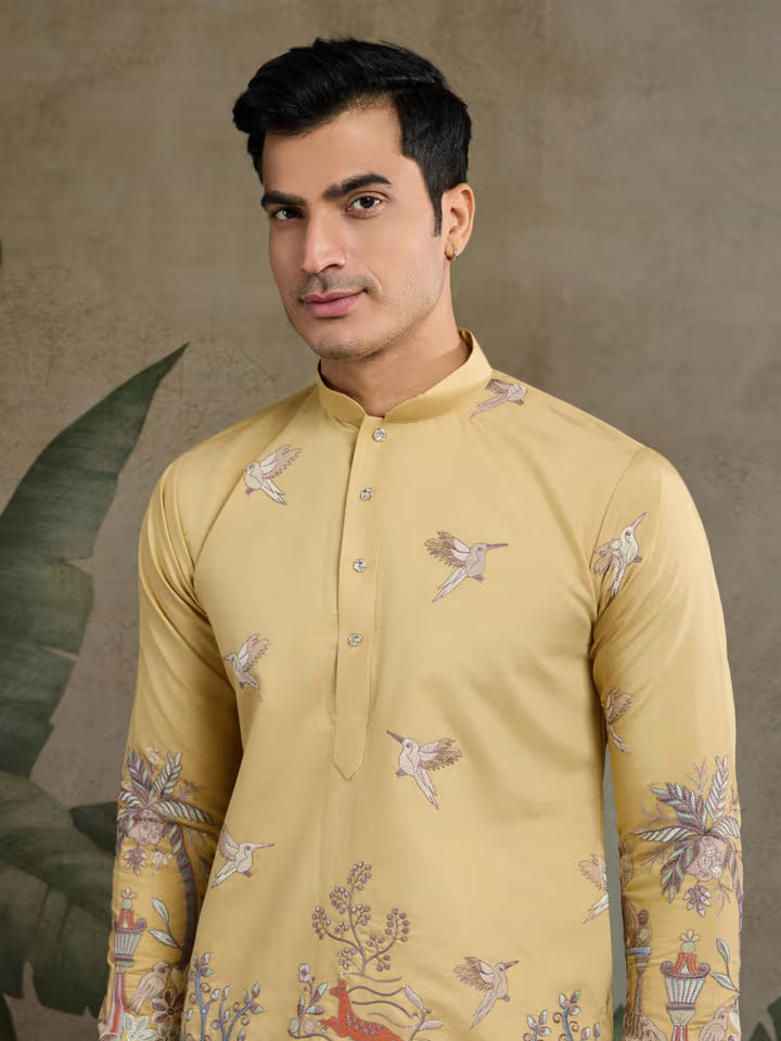 Man wearing a beige kurta with floral patterns against a neutral background