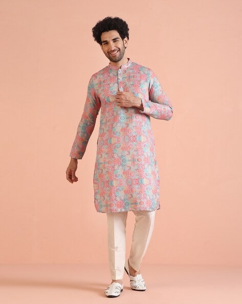Man wearing a pink floral printed short kurta with white pants – perfect for festive and party occasions