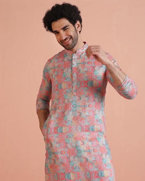 Man wearing a pink floral printed short kurta with white pants – perfect for festive and party occasions