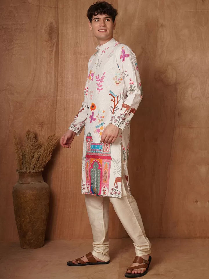 Man wearing a colorful embroidered kurta with beige pants against a wooden background