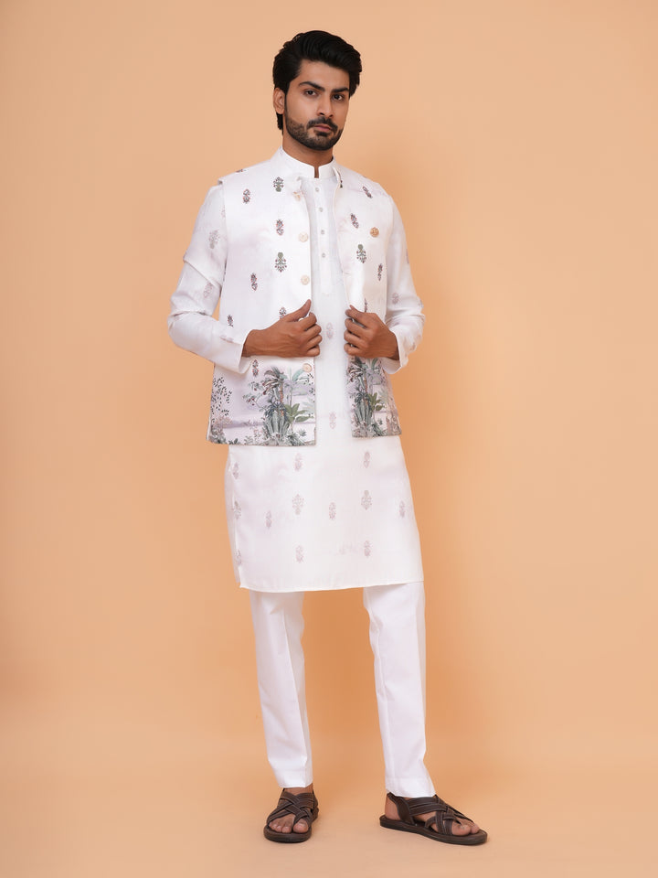 Man wearing a traditional white kurta with a patterned jacket on a beige background