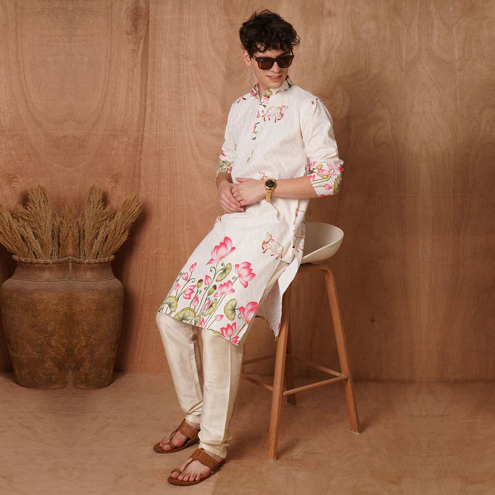 Person wearing a floral outfit sitting on a stool against a wooden wall.